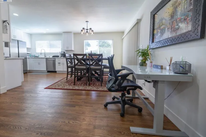 Elegant dining room with a contemporary chandelier, generous natural light, and an open floor plan ideal for entertaining. All furnishings and appliances are part of the sale.