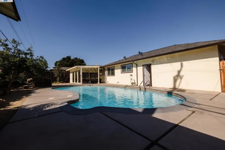 Enjoy a spacious 10-ft deep pool with a wide concrete deck, open yard, and plenty of sun—perfect for swimming, relaxing, or hosting. A great outdoor space ready for fun and comfort.