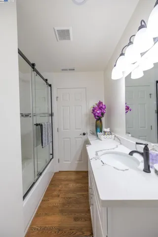 Beautifully updated bath with a wide quartz vanity, modern fixtures, glass-enclosed tub/shower, and elegant lighting. Clean lines and bright finishes create a spa-inspired feel in a thoughtfully designed layout. Essentials Included.