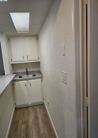 Wet bar is remodeled with new sink and stone counter tops and cabinetry