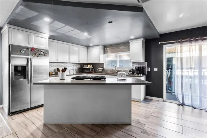Kitchen featuring stainless steel appliances, white cabinetry, and modern design