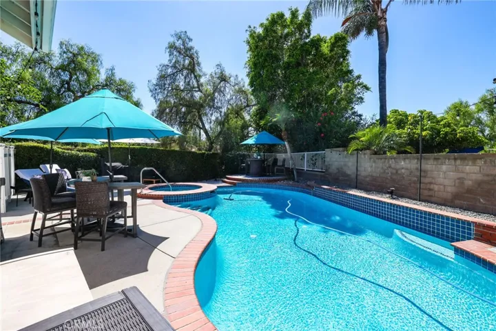 Resort-style pool area with ample lounging space and mature greenery.