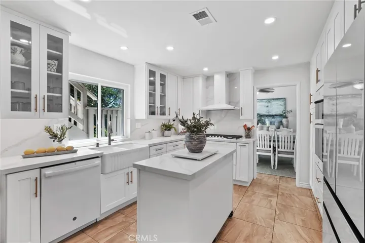 Open-concept kitchen and dining area with a large center island and recessed lighting.