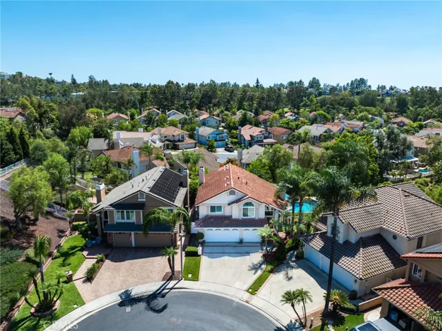 Aerial view of the property in a quiet, tree-lined neighborhood.
