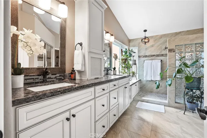 Luxurious primary bathroom with walk-in shower and dual vanities.