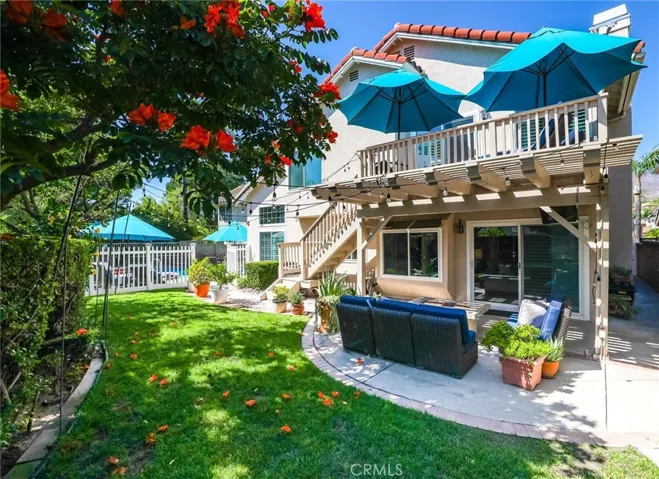 Beautifully landscaped backyard with multiple entertaining areas and pool access.