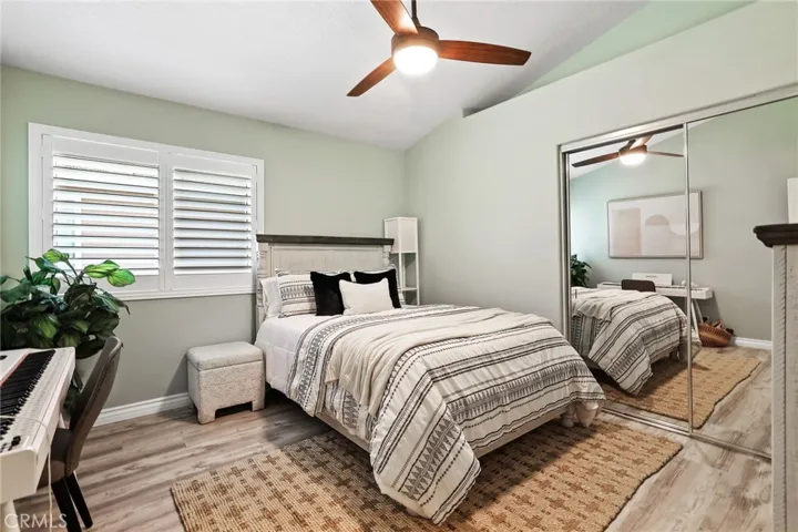 Bright secondary bedroom with ceiling fan and shutters!