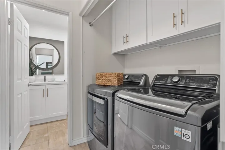 Convenient laundry room with sink, built-in cabinetry, and storage space.