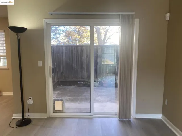 Doorway with wood finished floors and baseboards