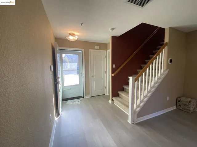 Entryway featuring stairway and light wood finished floors