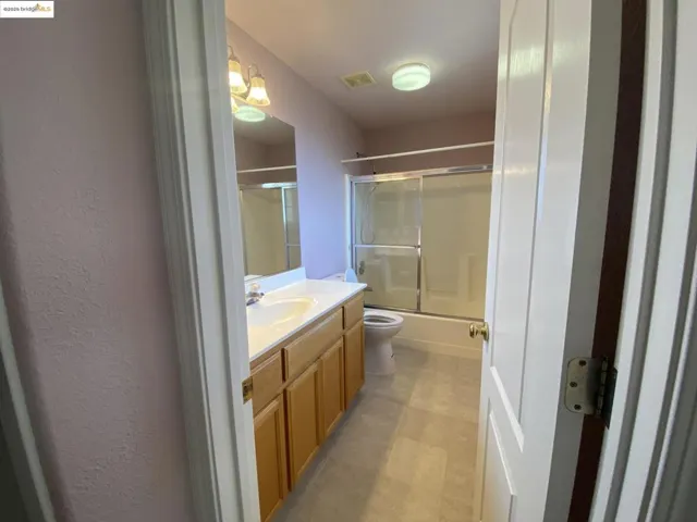 Bathroom with vanity and shower / bath combination with glass door