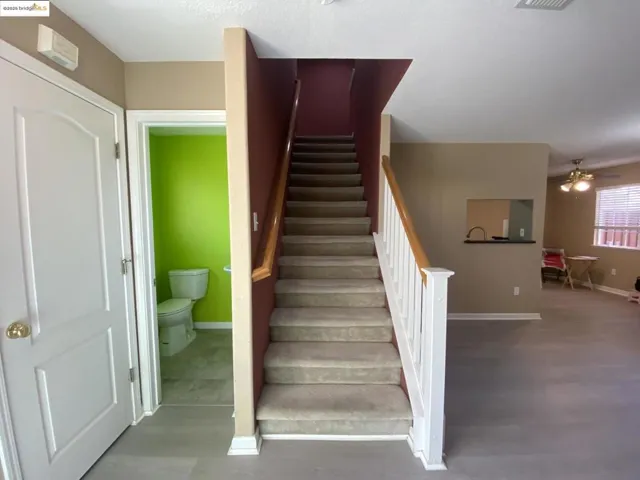 Staircase featuring baseboards and ceiling fan