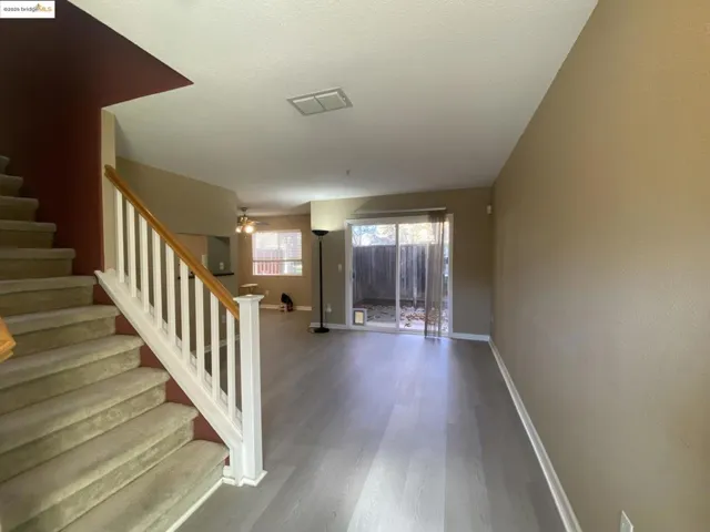 Carpeted Staircase featuring ceiling fan and entry wood finished floors