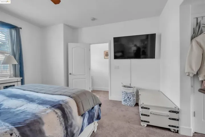 Bedroom with light colored carpet and a ceiling fan