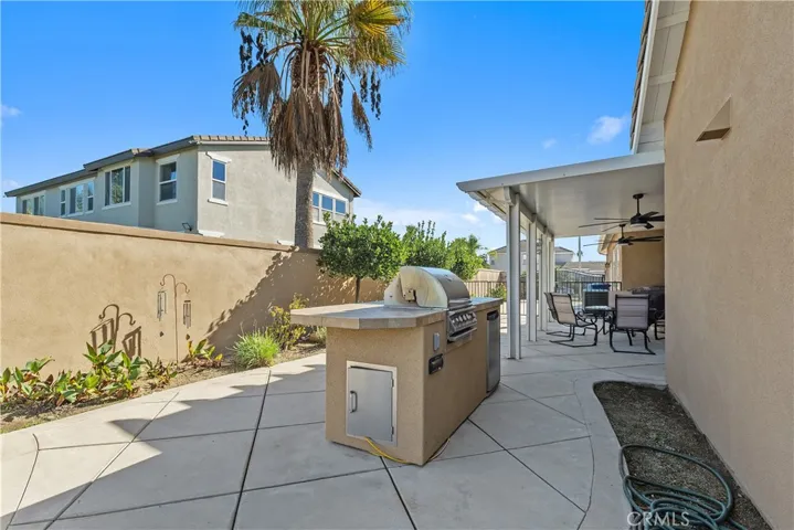 The side yard has a lovely concrete patio and a BBQ island for outdoor entertaining. The covered patio and dining area are off of the dining room.