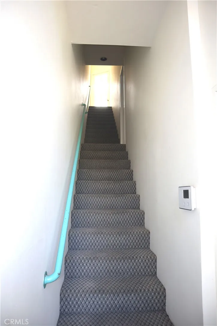 Stairs to upper apartment with view of hillside.