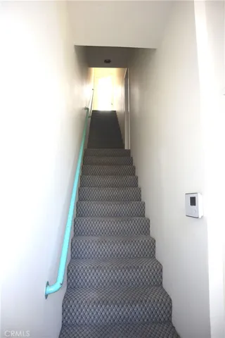 Stairs to upper apartment with view of hillside.