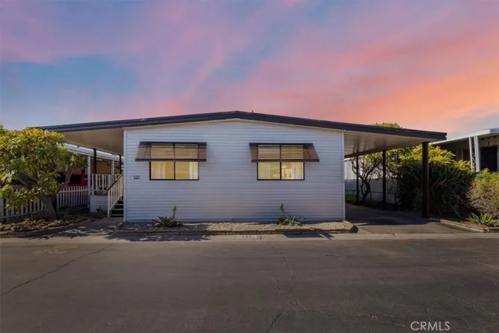 Exterior view of the home at 300 N Rampart St TRAILER 127, Orange, CA. Features a covered porch/carport area and well-maintained landscaping