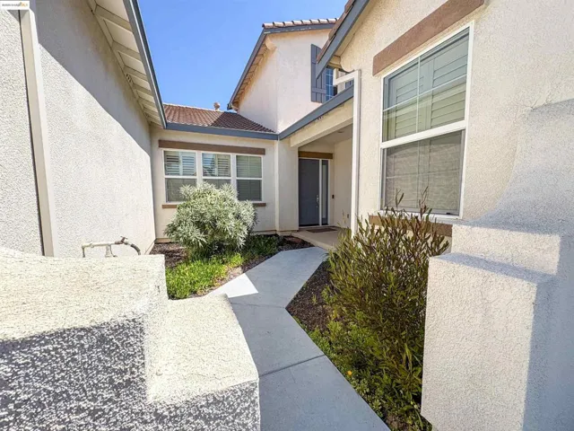 Property entrance with a tiled roof and stucco siding