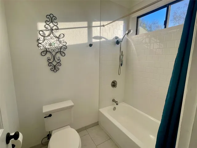 Clean and bright bath with tiled shower and tub.