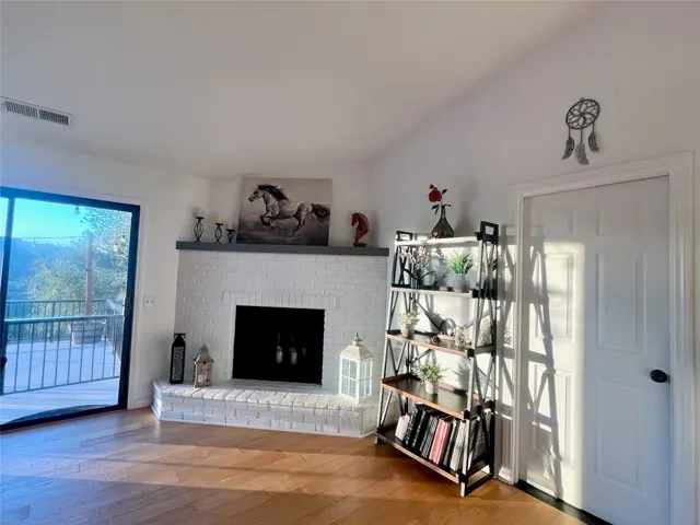 Cozy living room featuring a fireplace, large windows, and access to the deck.