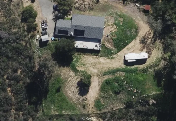Aerial view highlighting the home’s setting, usable land, and spacious layout.