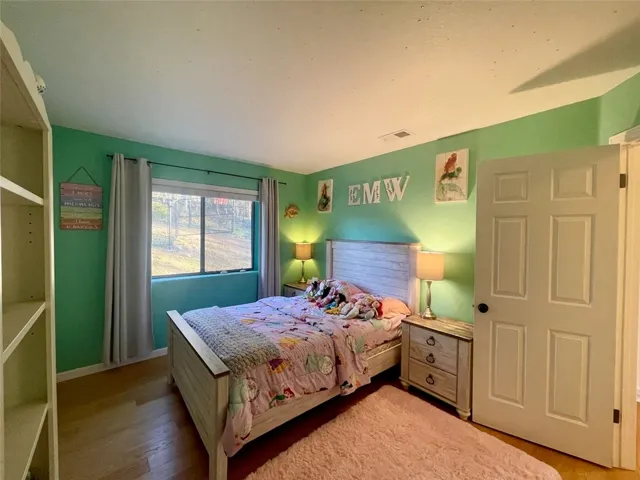 Comfortable secondary bedroom with closet and window overlooking the property.