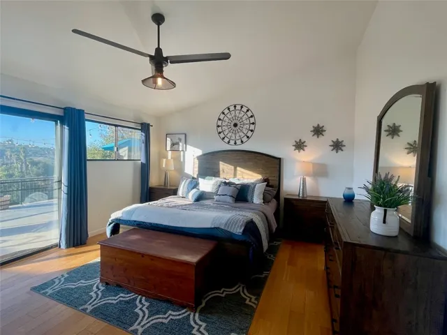 Spacious primary suite with ceiling fan, large windows, and deck access.