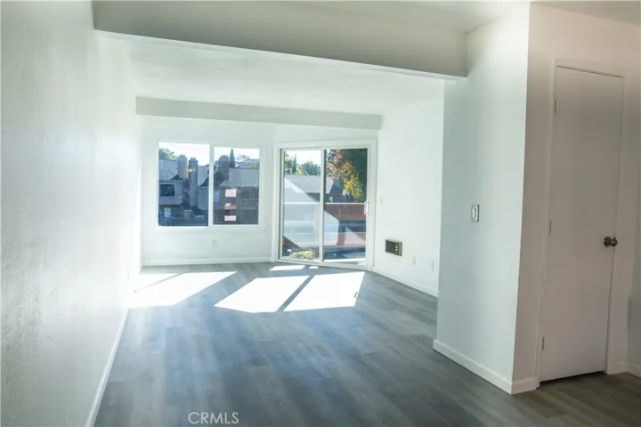 Living room with balcony and abundant natural light.  Private end unit, with new custom Milgard dual-paned windows.