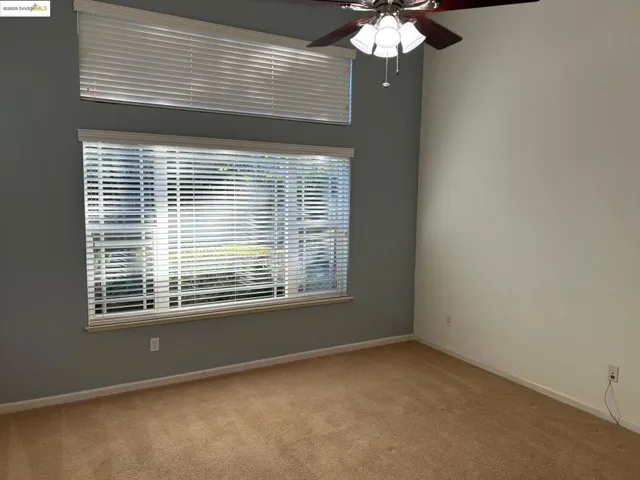Spare room featuring light carpet and ceiling fan