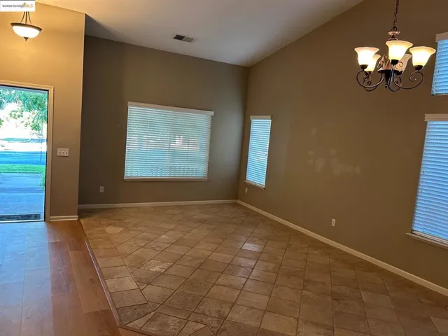 Foyer entrance with plenty of natural light, lofted ceiling, and a chandelier