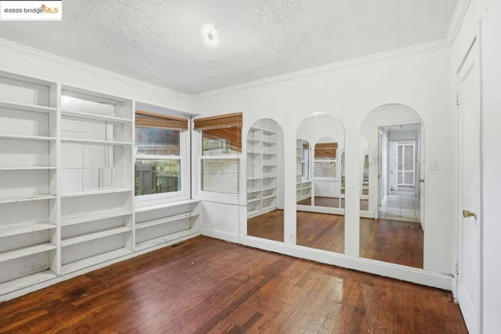 dark wood-style flooring and built in shelves