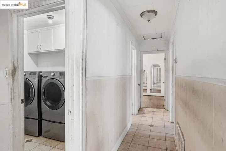 Laundry area featuring light tile patterned floors, cabinet space
