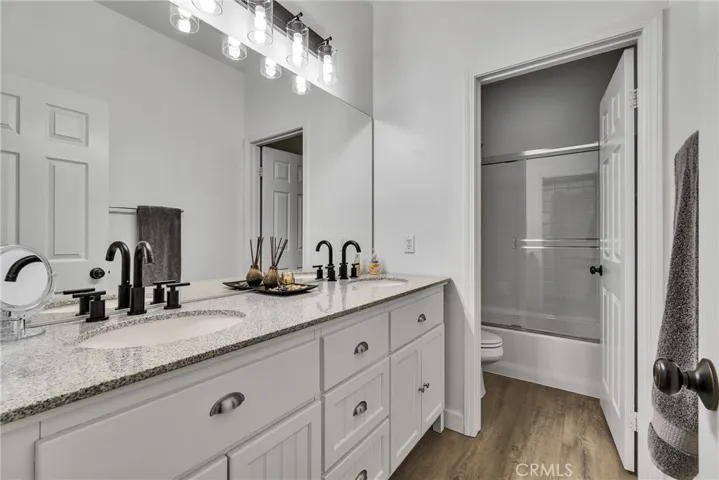 Hall bathroom double vanity shower over tub
