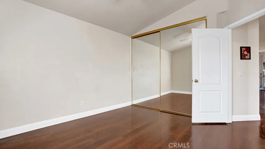 This guest bedroom has dual mirrored sliding closet doors.