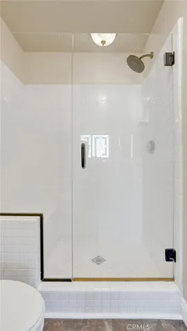 The primary bathroom has a walk in glass shower.