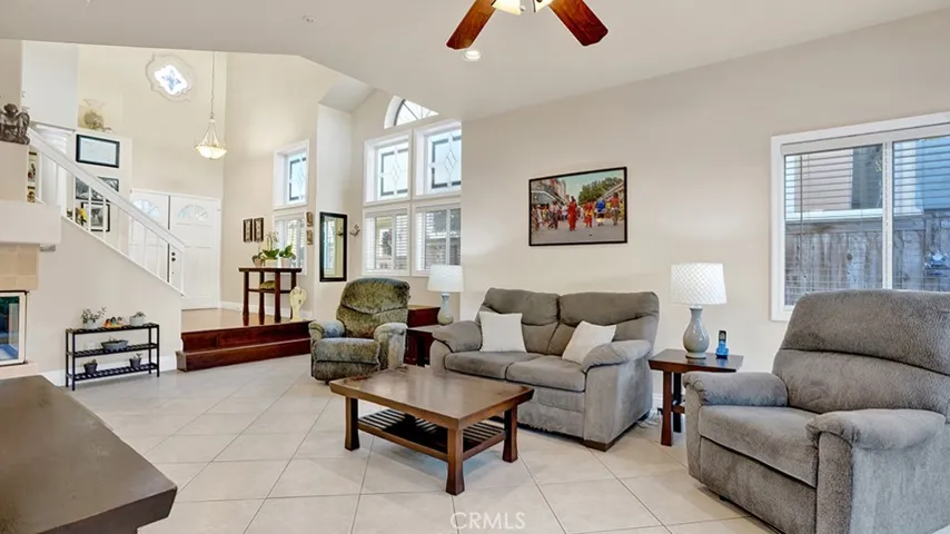The living room has plenty of windows as well as recessed lights installed in the ceiling.