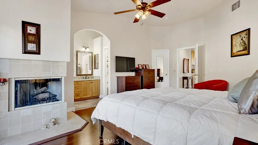 Another view of the primary bedroom which has a gas fireplace as well as a walk in closet plus an ensuite bathroom.