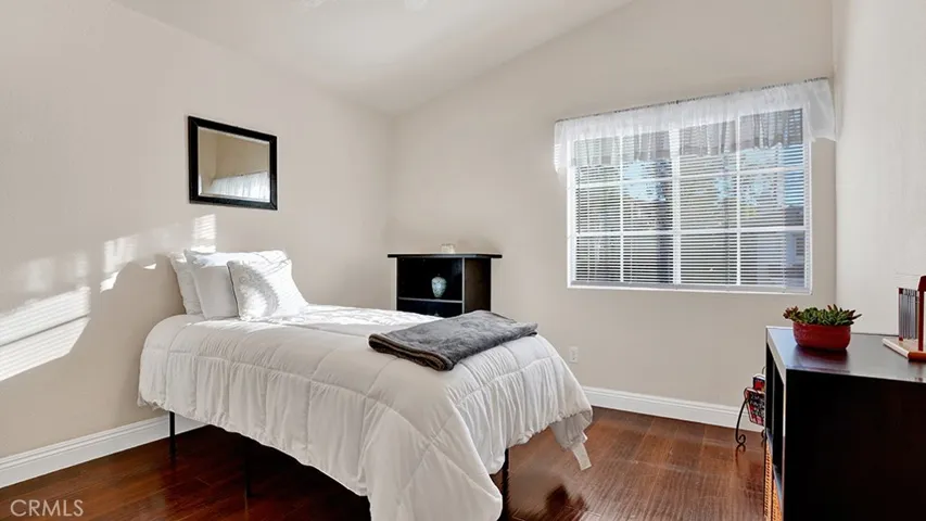 This guest bedroom has vaulted ceilings and a ceiling fan.