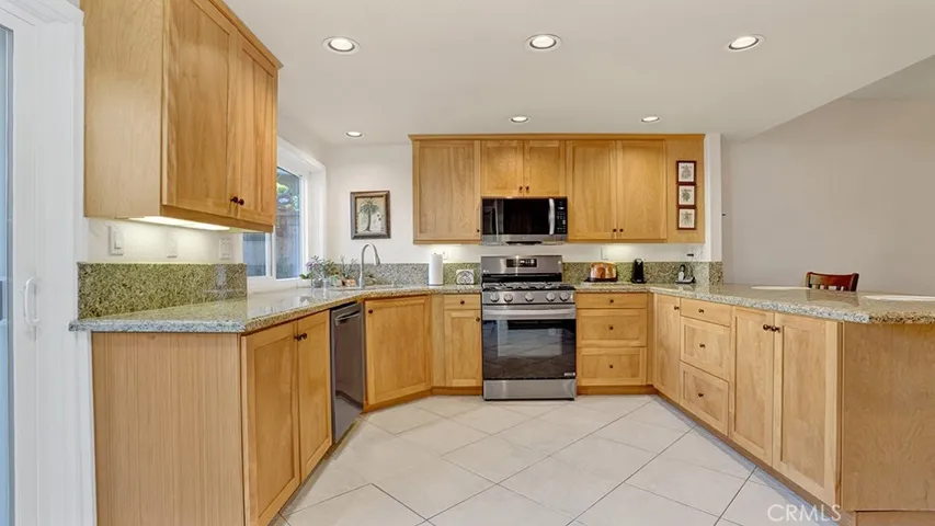 The kitchen has red birch cabinetry as well as stainless steel appliances.