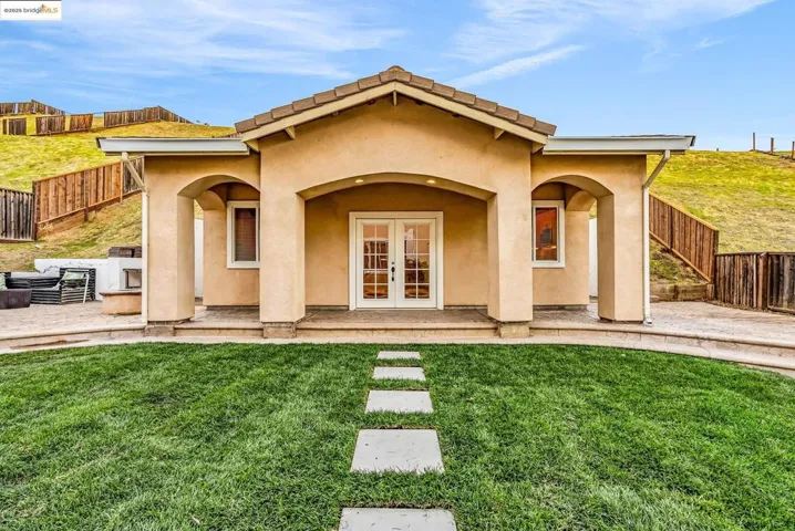 Back of house featuring french doors, stucco siding, and a patio area