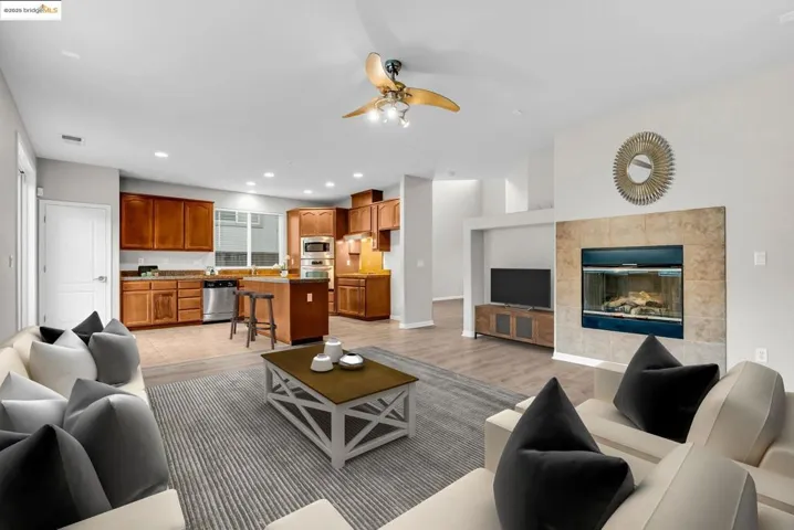 Living room featuring a ceiling fan, recessed lighting, and light wood-type flooring