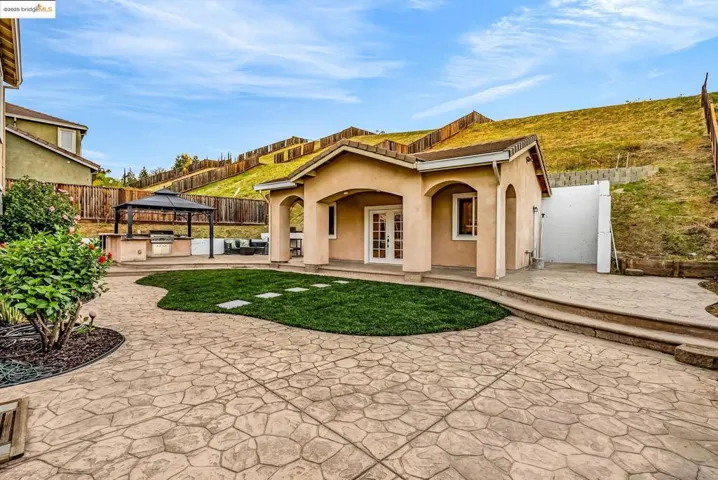 View of front of house featuring french doors, a patio area, a gazebo, a fenced backyard, and stucco siding