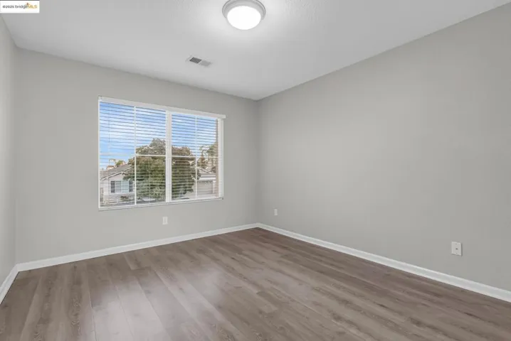 Unfurnished room with wood finished floors and baseboards