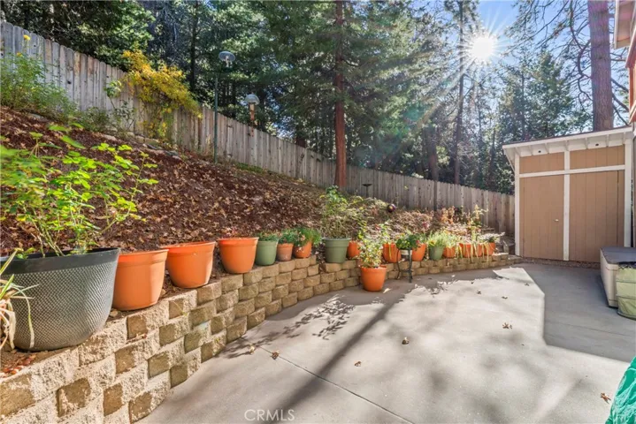 Fenced backyard with shed for extra storage.