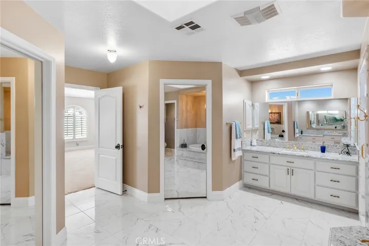 Two separate wardrobe rooms adorned with mirrored doors.