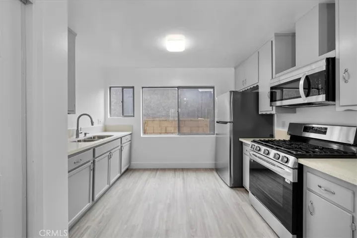 Kitchen includes fridge, oven, microwave & washer and dryer beside