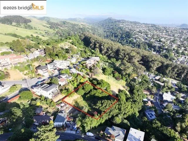 Aerial view of residential area featuring property parcel outlined and a mountain backdrop