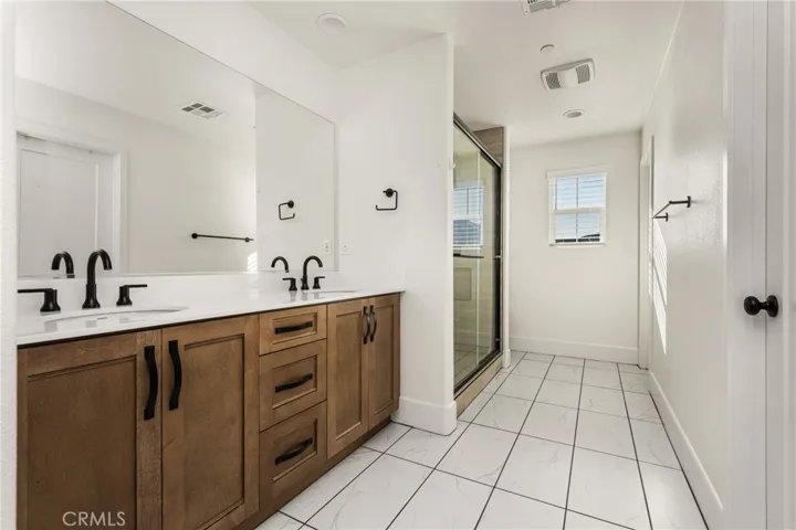 Primary bathroom with dual sinks and a walk-in shower for a spa-like daily routine.