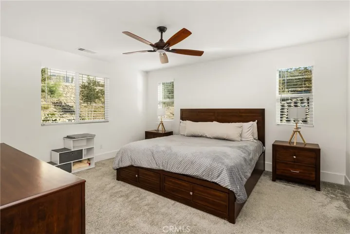 Spacious primary bedroom designed as a private retreat with ceiling fan for comfort.